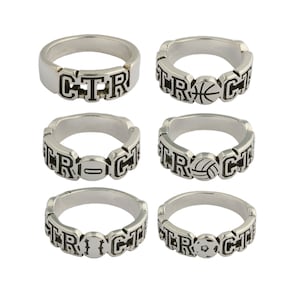 May include: Six silver rings with different sports designs. The rings feature the letters "CTR" and a basketball, football, baseball, volleyball, and soccer ball.