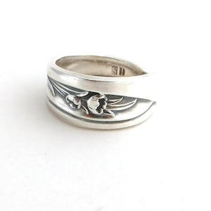 May include: A silver spoon ring with a floral design. The ring is marked "SD" on the inside.