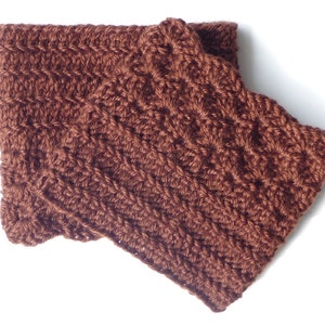 Puede incluir: Calientamanos de punto de ganchillo de color marrón. Los calientamanos están hechos con un patrón de punto texturizado.