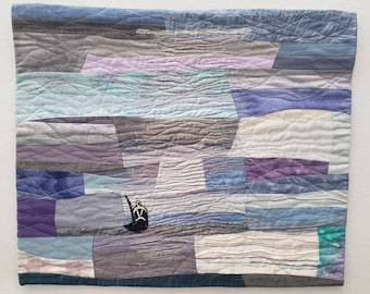 Fabric shorescape,wall hanging,art quilt, paddleboarder, shoreline,impressionistic  coastal scene,reflective water, blues, purples,whites