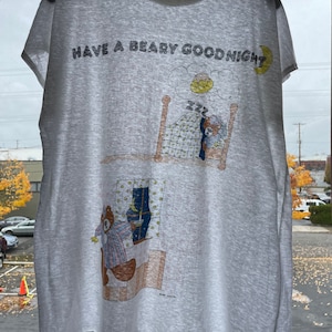 May include: A gray t-shirt with a cartoon illustration of a bear in bed and the text "HAVE A BEARY GOOD NIGHT".