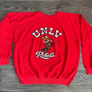 Sudadera UNLV Rebels estilo vintage de los 90. ¡Hey Reb! Universidad de Las Vegas. Estampado grueso. Sudadera vibrante estilo pullover. Talla XL (EE. UU.)