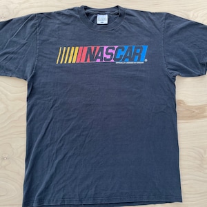 May include: Black t-shirt with a colorful NASCAR logo and the text "Officially Licensed by NASCAR".