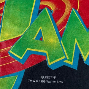May include: Black t-shirt featuring a green, yellow and blue "JAM" graphic with a red and yellow swirl design behind it. The text "FREEZE&reg; TM & &copy; 1996 Warner Bros." is printed below the graphic.