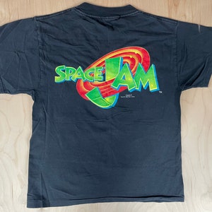 May include: Black t-shirt with a colourful Space Jam logo on the back. The logo features the words "Space Jam" in a stylised font with a red, yellow and green basketball hoop graphic.