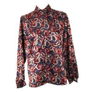 May include: A long-sleeved button-up shirt with a colorful abstract pattern. The shirt is made of a silky material and has a relaxed fit.