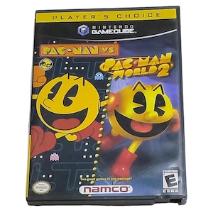 May include: A Nintendo GameCube video game case for Pac-Man Vs. and Pac-Man World 2. The cover features the yellow Pac-Man character, the Namco logo, a Player's Choice banner, and an ESRB E rating. The background displays a dark maze pattern.