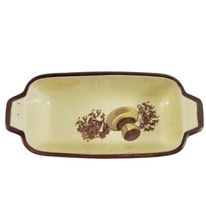 May include: A rectangular ceramic baking dish with brown rim and handles. The dish has a light yellow background with a brown mushroom design.