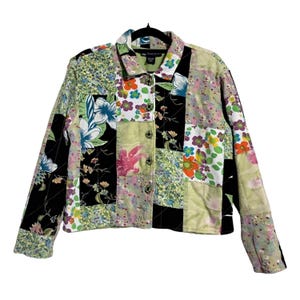 May include: A patchwork jacket with a floral pattern in various colors, including green, black, pink, and white. The jacket has a button-up front and a collar. The jacket is approximately 24 inches long.