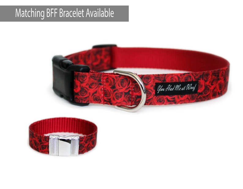 May include: Red dog collar with a black and white rose print and the text "You Had Me At Woof". A matching red bracelet with the same print is also shown.