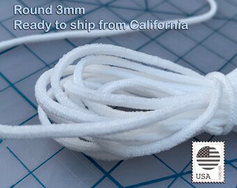 May include: White elastic cord, 3mm round, ready to ship from California.  The cord is coiled on a blue and white grid surface.  A US postage stamp is in the lower right corner of the image.
