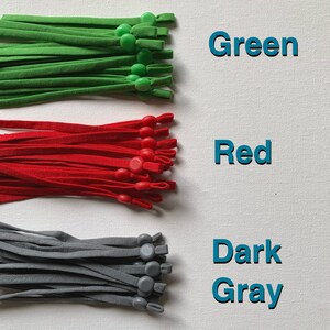 May include: Three bundles of elastic cord with adjustable toggles. The cords are green, red, and dark gray.