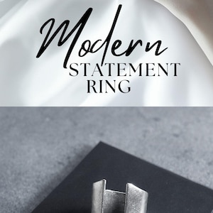 This ring has a minimalist, open-split design made from brushed metal, creating a striking, architectural look. The split shape gives it an edgy yet refined vibe, fitting seamlessly into styles that embrace simplicity and boldness