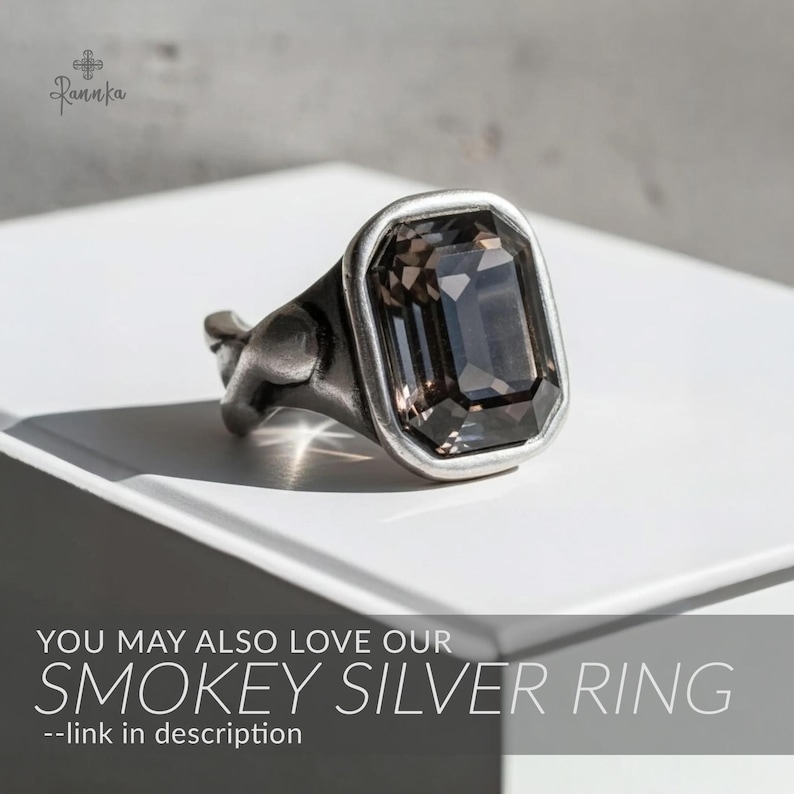 May include: Smokey silver ring with a large, rectangular, dark gray gemstone. The ring has a silver-tone band and setting. The image includes the text "YOU MAY ALSO LOVE OUR SMOKEY SILVER RING --link in description."