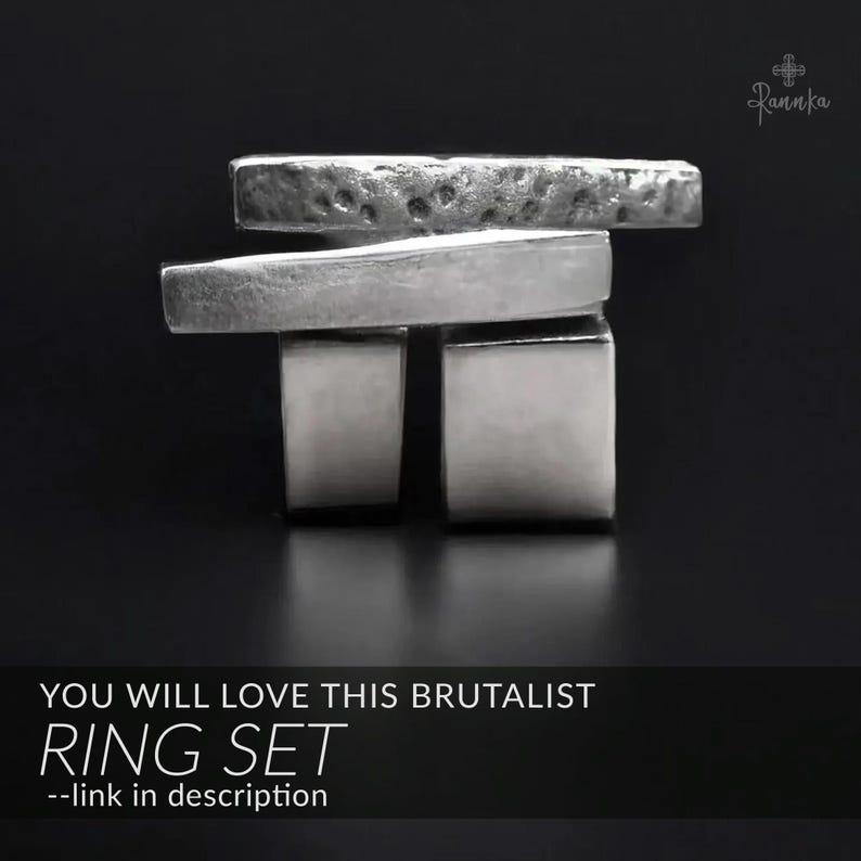 May include: A silver ring set with a brutalist design. The set includes two square-shaped rings and two rectangular rings. The top ring has a textured surface. The text "YOU WILL LOVE THIS BRUTALIST RING SET" is displayed at the bottom.