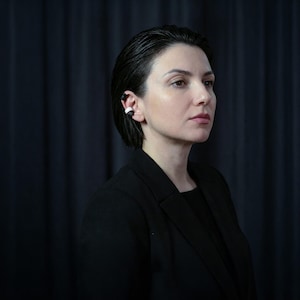 Black and white ear cuff set worn without ear piercings, stacked ear jewelry hugging the ear rim, modern no hole earrings styled on model in dark studio setting, minimalist ear accessories with matte finish, contemporary sculptural ear jewelry by Rannka.