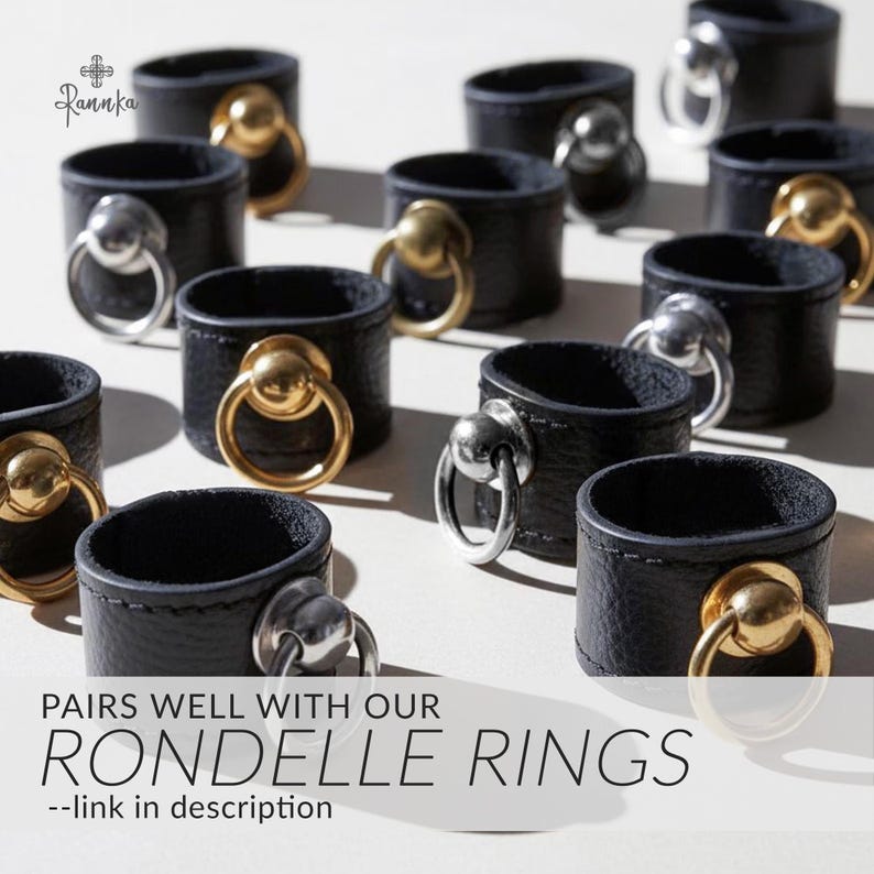 May include: Black leather ring holders with gold and silver metal rings. The holders are arranged on a white surface. The text "PAIRS WELL WITH OUR RONDELLE RINGS" is displayed at the bottom of the image.