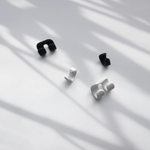 Adjustable Earrings in black and white, double and single No-Pierced Conch Wraps on white surface with trendy shadowing