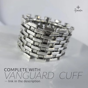 May include: A silver-colored ring with a woven brickwork design. The ring is wide and has a textured surface. Text on the image reads "COMPLETE WITH VANGUARD CUFF -- link in the description."