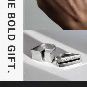 May include: Two silver rings with a geometric design. One ring is on a hand, the other two rings are displayed separately. The text reads: "TWO RINGS. ONE BOLD GIFT." and "-Minimal. Geometric. Made to be worn together.-"