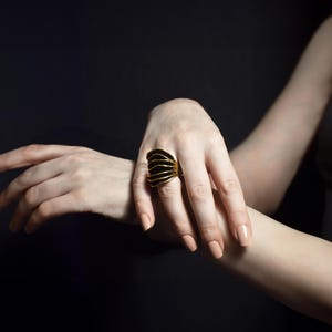 elegant women's hands and on one is a large statement cocktail gold ring