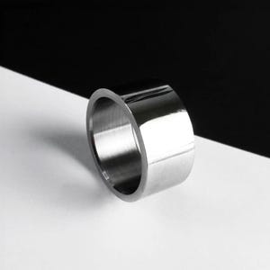 Everyday Ring for Women steel band, Wide silver band ring photographed on a black and white background. Smooth reflective polished ring with clean edges, creating a minimal and modern look.