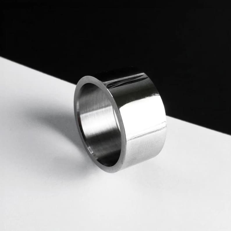 Everyday Ring for Women steel band, Wide silver band ring photographed on a black and white background. Smooth reflective polished ring with clean edges, creating a minimal and modern look.