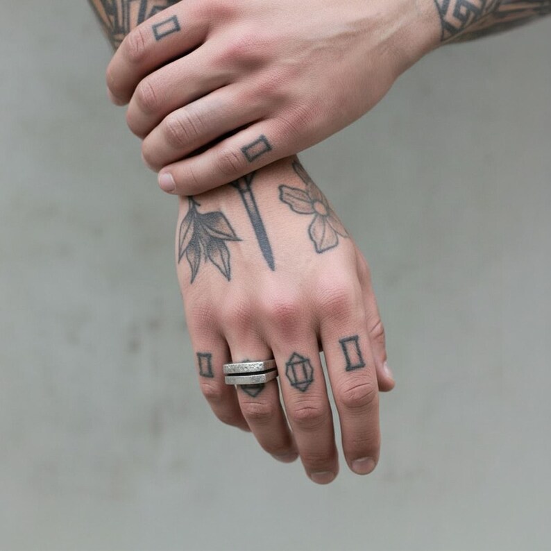Tattooed hand wearing a geometric silver bar ring with a hammered finish. The ring’s stacked structure adds an industrial edge to the minimalist look. Unisex modern jewelry piece for everyday wear. Rannka handcrafted design.