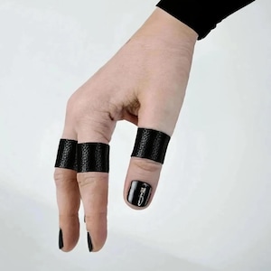 Ring Leather Contemporary Jewelry Birthday Gift for Him, Hand wearing three slim black vegan leather finger bands with textured surface, paired with black nail polish, photographed against a light neutral background.