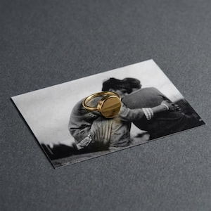 gold signet ring resting over a vintage black and white photograph, memory and object layered into one quiet moment, a subtle Rannka touch where form holds something personal