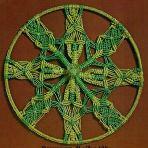 Könnte beinhalten: Ein grünes und gelbes Makramee-Mandala mit einem kreisförmigen Design. Das Mandala ist aus geknüpften Schnüren gefertigt und hat ein sternenförmiges Muster.