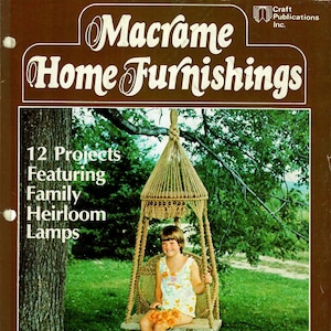 May include: A book cover with a brown background and the title "Macrame Home Furnishings". The cover features a macrame hanging chair with a young girl sitting in it. The book title is in white text with a decorative font. The book cover also includes the text "12 Projects Featuring Family Heirloom Lamps" and "By Lynn Witbeck".