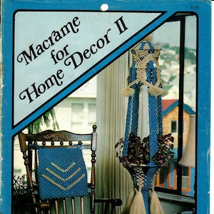 May include: A book cover for a macrame pattern book titled "Macrame for Home Decor II". The cover features a blue and white macrame plant hanger with a plant inside. The book is priced at $1.95.