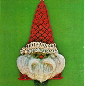 May include: A red and white crocheted Santa Claus ornament with a white beard and a red hat. The ornament has a gold loop at the top for hanging.