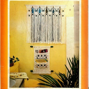 Könnte beinhalten: Ein gelbes Badezimmer mit einem weißen Makramee-Fenstergardine und einem weißen Makramee-Zeitschriftenhalter. Der Zeitschriftenhalter enthält eine Zeitschrift mit dem Wort "RELI"