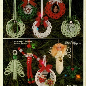 Puede incluir: Una colección de adornos navideños hechos a mano con hilo. Los adornos incluyen una corona con la palabra "JOY" en el centro, un ángel volando, un árbol de Navidad, una esfera con un Papá Noel dentro y un diseño de hoja de acebo.