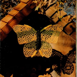 Puede incluir: Un tapiz de pared de ganchillo en forma de mariposa amarillo y verde con el texto "Libra Pattern on Page 14" y "Page 15" en la parte inferior de la imagen.