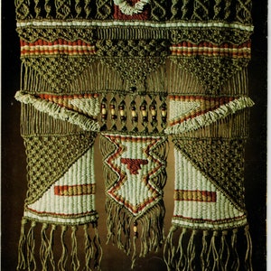 Op de afbeelding: Een macramé wandhanger met een geometrisch ontwerp in tinten bruin, wit en rood. De hanger heeft een centrale diamantvorm met franjes en kralen.