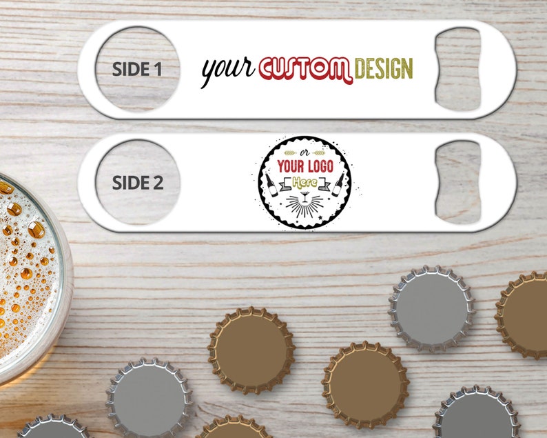 May include: Two white metal bottle openers with a bottle opener on one end and a round hole on the other end. The top opener has the text 'SIDE 1 your CUSTOM DESIGN' and the bottom opener has the text 'SIDE 2 or YOUR LOGO Here'. The openers are on a woodgrain surface with several bottle caps.