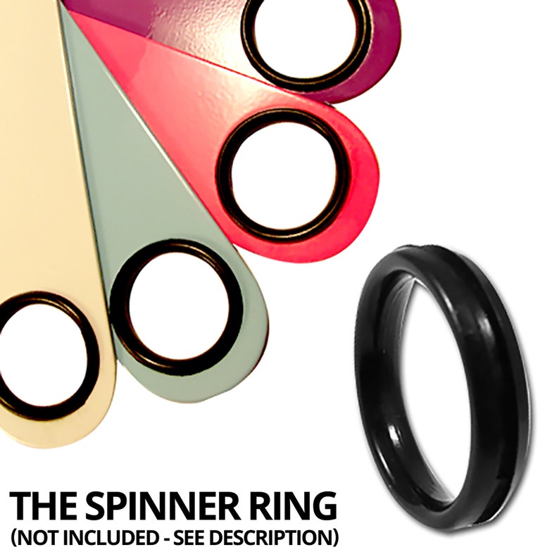May include: Five colorful, teardrop-shaped pieces of plastic with a black ring in the center of each. The pieces are arranged in a semi-circle. The colors are purple, pink, light blue, cream, and black. The black ring is a spinner ring, and the text below the image reads 'THE SPINNER RING (NOT INCLUDED - SEE DESCRIPTION)'