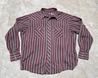 May include: A long-sleeved button-down shirt with a striped pattern in shades of burgundy and gray. The shirt has two chest pockets and a pointed collar.