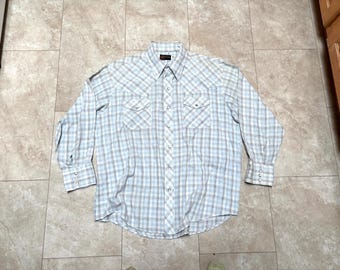 May include: A long-sleeved, button-down plaid shirt with a white background and brown and blue plaid pattern. The shirt has two chest pockets and a pointed collar.
