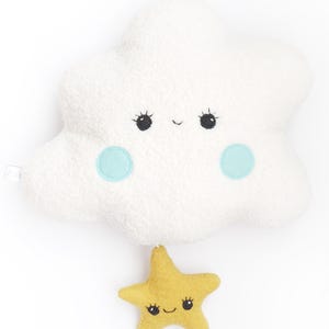 Può includere: Una nuvola di peluche bianca con un viso sorridente e occhi blu, che tiene una stella di peluche gialla con un viso sorridente e occhi neri.