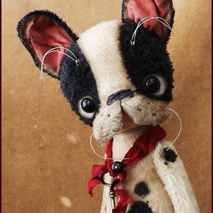 May include: A handmade plush French Bulldog with black and white fur, large black eyes, and a red ribbon with a key pendant. The dog has a whimsical, vintage aesthetic, with visible stitching and a slightly distressed appearance.