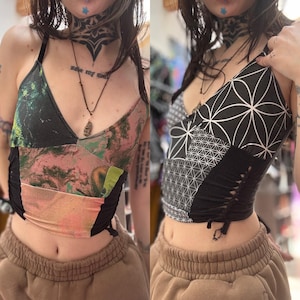 May include: Two women wearing different styles of black and white patchwork crop tops with geometric patterns. The tops have a v-neck and are tied at the waist. The tops are made of different fabrics and have a unique, handmade look.