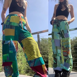 May include: Two pairs of patchwork pants with a variety of colorful fabrics and patterns. One pair is green, blue, and yellow with a tie-dye pattern. The other pair is blue, green, and white with a graphic print of a car and the words "Happy Camper".
