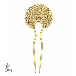 Può includere: Una forcina per capelli in metallo color oro caratterizzata da una grande parte decorativa circolare in stile filigrana, con un motivo simmetrico ripetitivo a forma di petalo che si irradia da un punto centrale, fissata a una base a due punte a U.