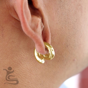 May include: Gold hoop earring for stretched earlobes. The hoop is made of two interlocking circles.