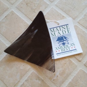 May include: A black triangular glass dish with a white tag that reads "Maine Made America's Best www.mainemade.com"