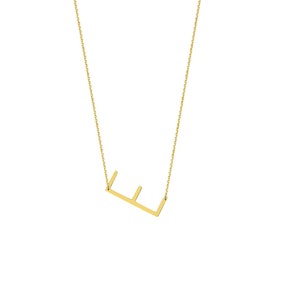 Puede incluir: Un collar de cadena dorada con un colgante de letra 'E' simple y minimalista.